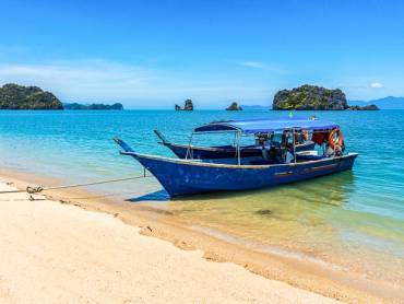 Traditionelles Holzboot am tropischen Strand auf Langkawi
